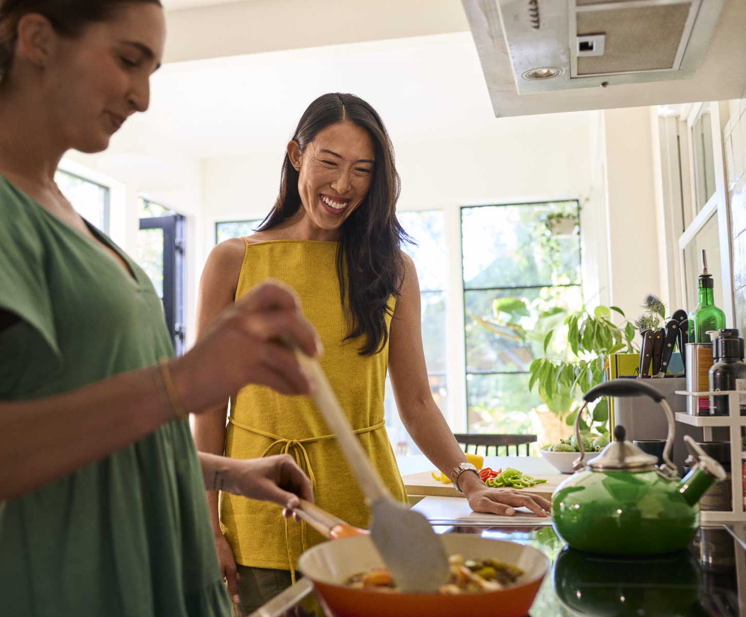 Two friends cooking in electric kitchen