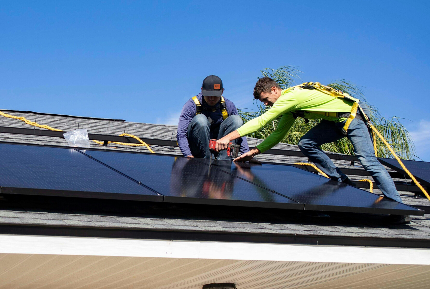Solar technicians installing panel on roof