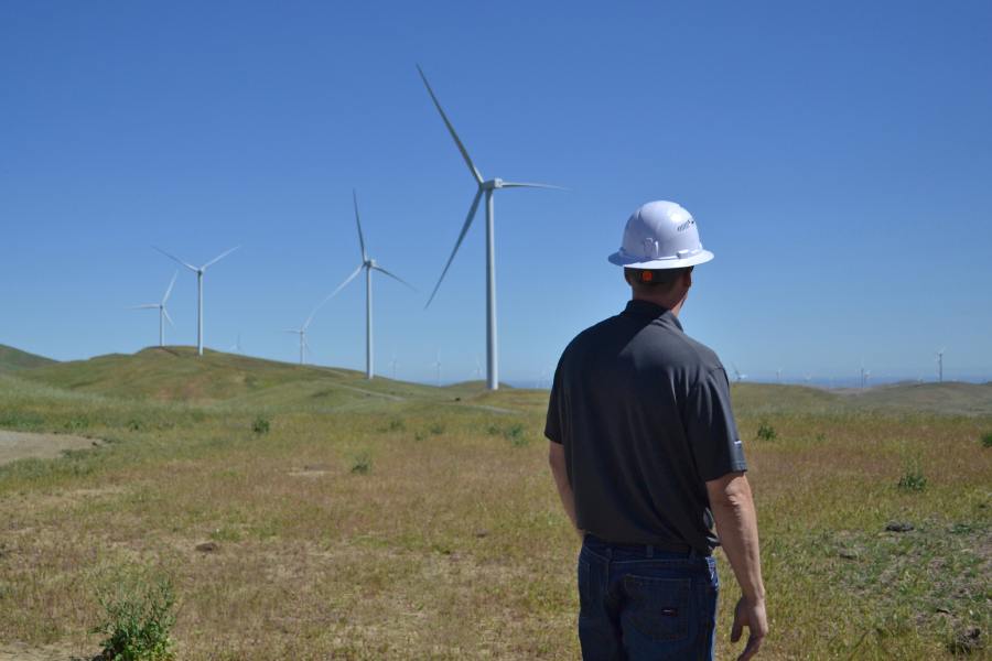 Man looking at wind turbines in the distance at Ava's Scott Haggerty Wind Energy Center