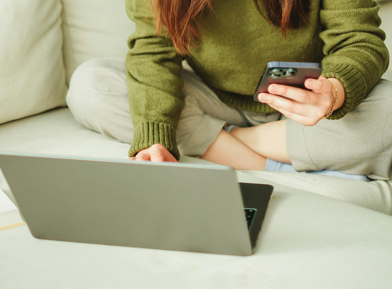 Woman looking at laptop and phone