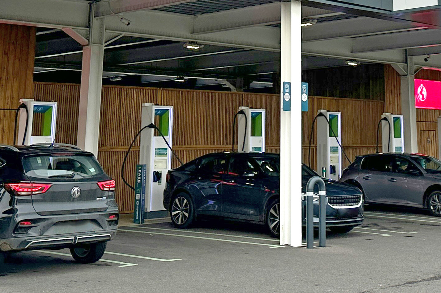 Three Evs Parked At A Charging Station, With One Full Parking Space In Between Each Of Them