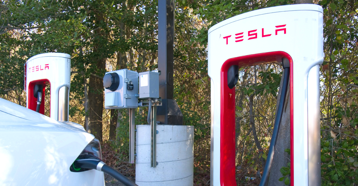 A Car Plugged Into A Charger At A Tesla Supercharger Site