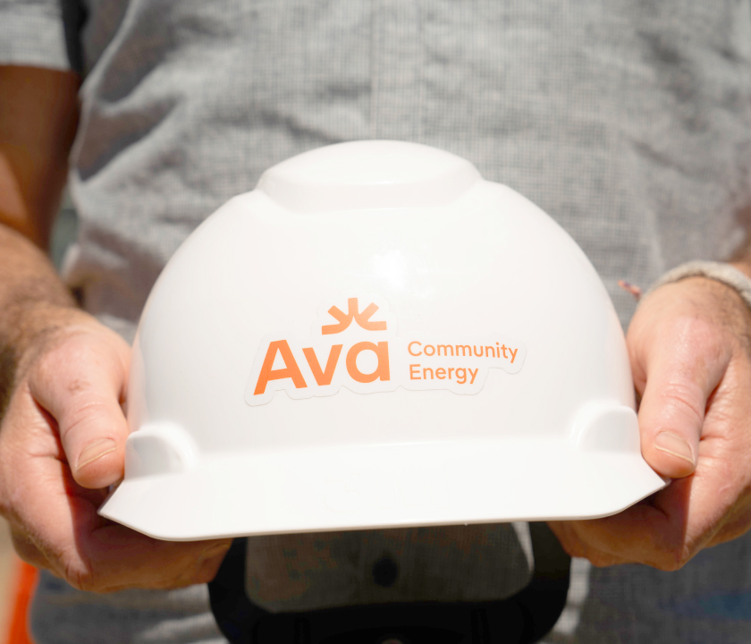 A hard hat with the Ava Community Energy logo on it