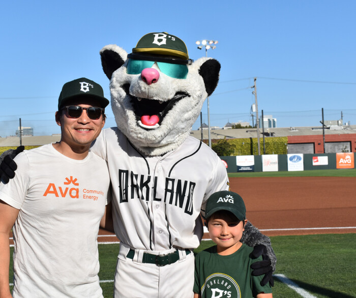 Ava CEO Howard Chang and his son stand with Scrappy on the field at Raimondi